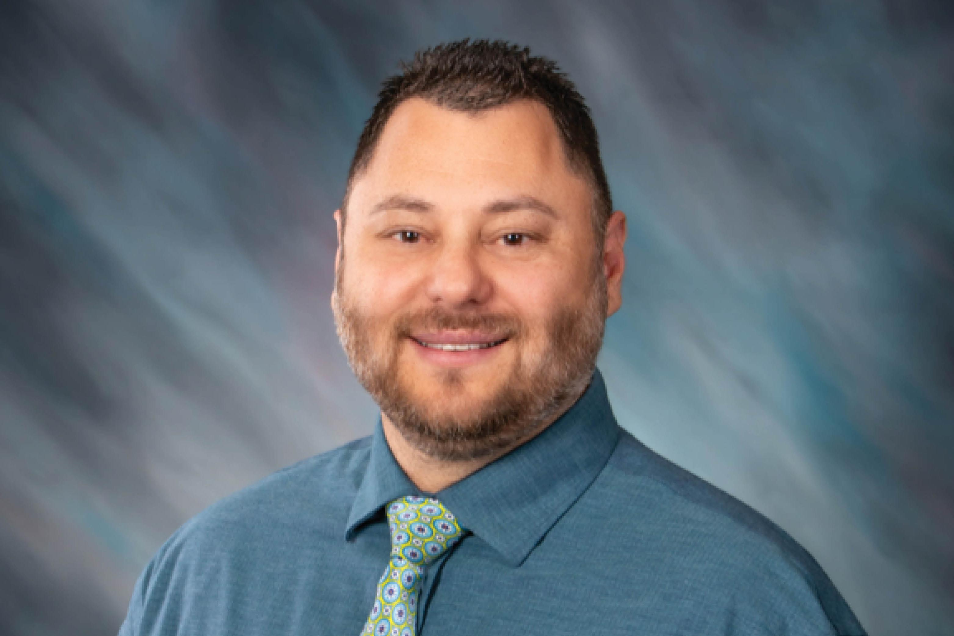 headshot of dr. cano on a blue background